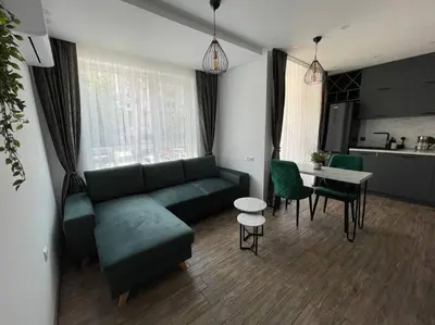 a living room with a green couch and a table at Studio Green Зелено Студио in Burgas City