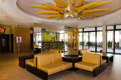 a lobby with yellow chairs and a ceiling at Royal Sun Complex in Sunny Beach