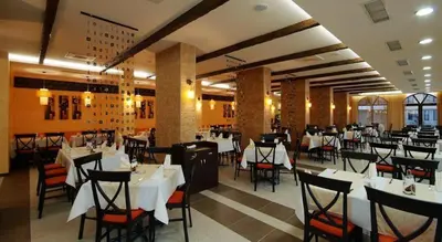 a dining room with tables and chairs and white tables at Royal Sun Complex in Sunny Beach