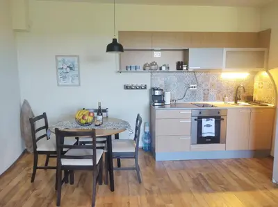 a kitchen and dining room with a table and chairs at Апартамент в Oasis beach Kamchia - Стъпки в пясъка in Kamchia