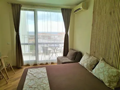 a living room with a bed and a large window at Elisa Studio in Byala