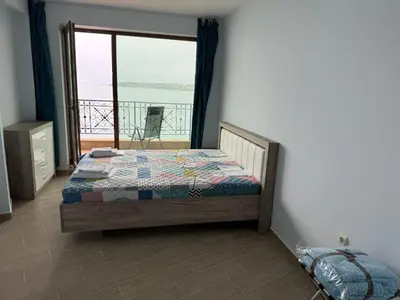 a bedroom with a bed and a view of the ocean at Sea View 2BR Apartment Sozopol in Sozopol