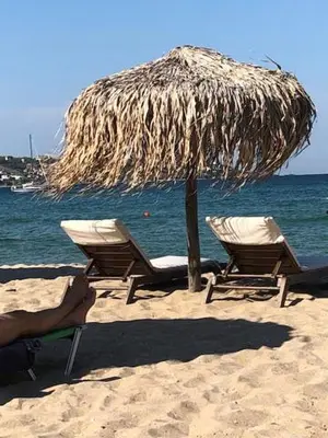 two chairs and a straw umbrella on the beach at Bułgaria na lato apartament z widokiem na morze Sozopol in Sozopol