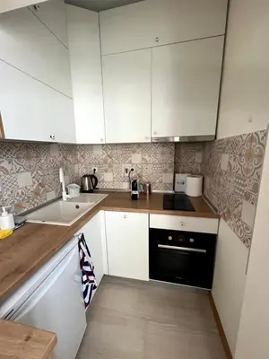 a small kitchen with white cabinets and a sink at Sea Vibes - Modern Apartment Near the Beach & City Center, Burgas in Burgas City