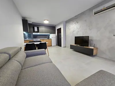 a living room with a couch and a flat screen tv at Horizont Apartment Sozopol in Sozopol