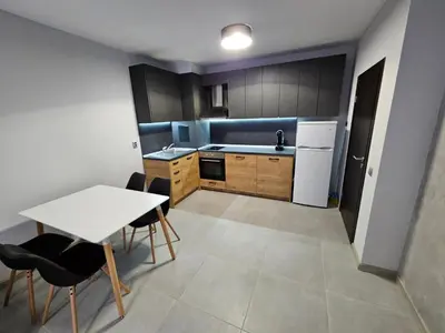 a small kitchen with a white table and chairs at Horizont Apartment Sozopol in Sozopol