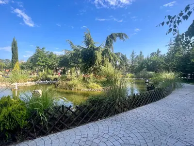 a pond in a park next to a walkway at Wonderful Deluxe Appartement in Cascadas Family Resort Sunny Beach in Sunny Beach