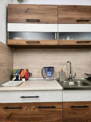 a kitchen with a sink and wooden cabinets at Синьо лято /Blue summer in Sunny Beach