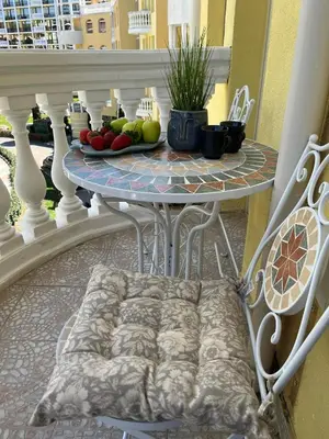 a table and chairs on a balcony with fruit on it at Синьо лято /Blue summer in Sunny Beach