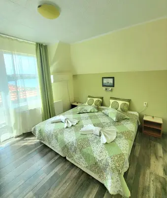 a bedroom with a bed with two towels on it at Penthouse Apartments PERLA, Vasiliko in Tsarevo