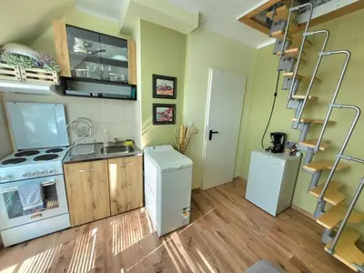 a small kitchen with a stove and a refrigerator at Penthouse Apartments PERLA, Vasiliko in Tsarevo