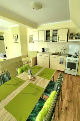 a living room with a table and a kitchen at Penthouse Apartments PERLA, Vasiliko in Tsarevo
