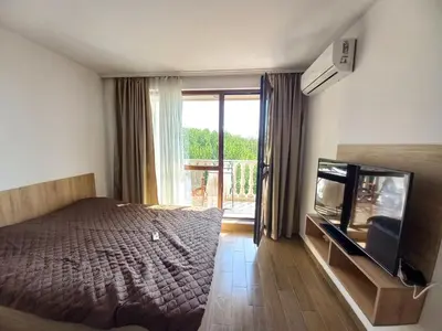 a bedroom with a bed and a flat screen tv at Cascadas Family Resort in Sunny Beach
