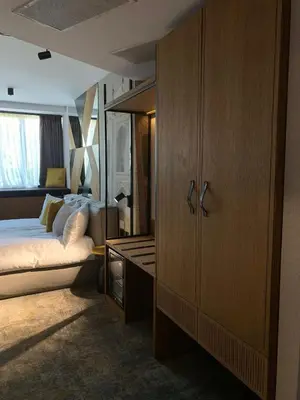 a bedroom with a bed and a wooden cabinet at MM Boutique Hotel in Burgas City