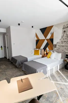 a hotel room with two beds and a table at MM Boutique Hotel in Burgas City