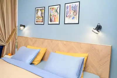 a bedroom with a bed with blue and yellow pillows at Design Studio in Atlantis Resort&SPA, Burgas Airport in Burgas City