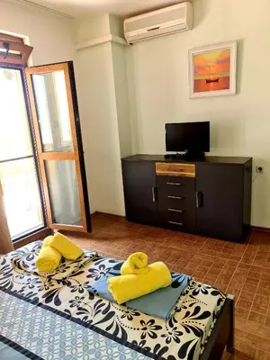 a bedroom with a bed with yellow towels on it at Цар Калоян in Primorsko