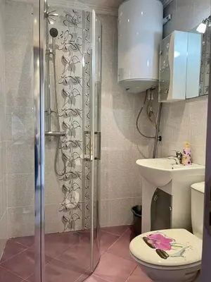 a bathroom with a shower and a toilet and a sink at Апартамент Чаролит / Apartment Charoite in Burgas City