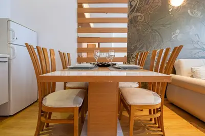 a dining room table with chairs and a kitchen at Sweet Homes 2 Holiday Apartment in Sunny Beach