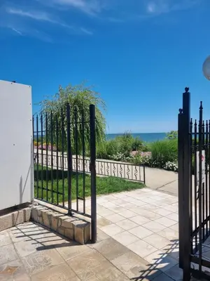 a black fence with the ocean in the background at Prestige Fort Beach apartment, Studio in Sveti Vlas