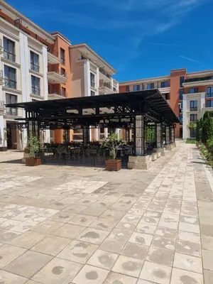 a pavilion with tables and chairs in a courtyard at Prestige Fort Beach apartment, Studio in Sveti Vlas