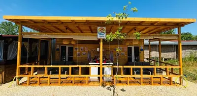 a wooden pergola with a table and chairs at CozyHut Бунгало под Наем in Chernomorets