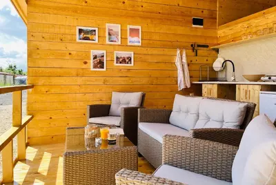 a patio with two wicker chairs and a table at CozyHut Бунгало под Наем in Chernomorets