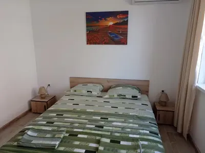 a bedroom with a bed with a green comforter at Екзарх Йосиф in Tsarevo