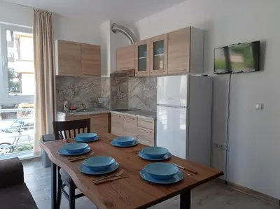 a kitchen with a wooden table with blue plates on it at Екзарх Йосиф in Tsarevo