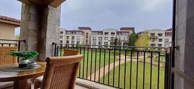 a balcony with a table and chairs and a view of a building at Апартамент Blue в местност Каваци, Созопол in Sozopol
