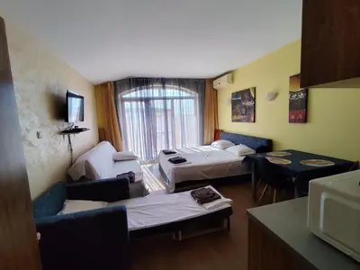 a hotel room with two beds and a living room at Апартхотел Роял Дриймс in Sunny Beach