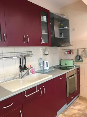 a kitchen with red cabinets and a sink at Star Ray Apartment in Varna City
