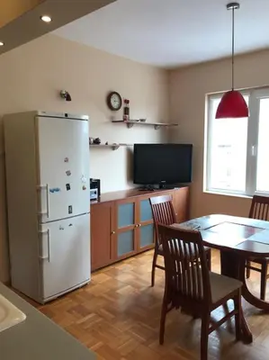 a kitchen with a table and a white refrigerator at Star Ray Apartment in Varna City