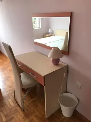 a desk with a lamp and a mirror on a wall at Star Ray Apartment in Varna City