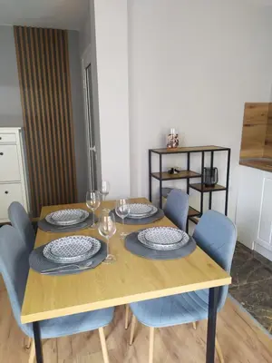 a wooden table with chairs and plates and wine glasses at Студио Ирма in Burgas City