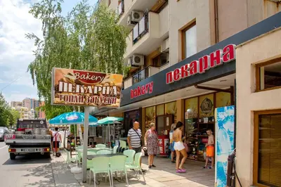 a group of people walking on a sidewalk in front of a restaurant at TSB Roxy Apartments in Sunny Beach