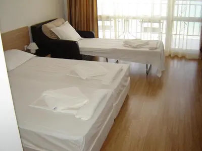 two beds in a hotel room with white sheets at Villa Lazuren Bryag 2 in Chernomorets