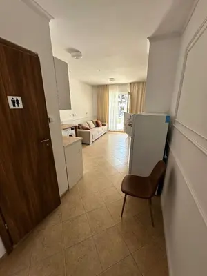 a kitchen with a refrigerator and a chair in a room at Horizont Apartments in Sunny Beach