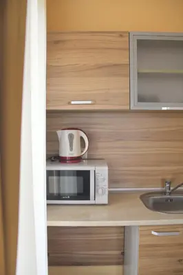 a microwave oven with a bowl on top of it at Horizont Apartments in Sunny Beach
