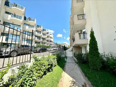 an apartment complex with cars parked in a parking lot at Ipanema Beach - Menada Apartments in Sveti Vlas