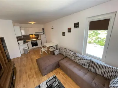 a living room with a couch and a large window at Ipanema Beach - Menada Apartments in Sveti Vlas