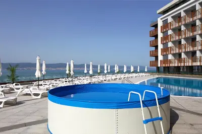 a pool with a hot tub next to a building at Sea View Apartment In PARADISO in Nesebar