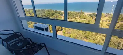 a chair in front of a window with a view of the ocean at SEA VIEW FLORA in Burgas City