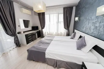 a bedroom with a large bed and a large window at Polina Beach in Sozopol