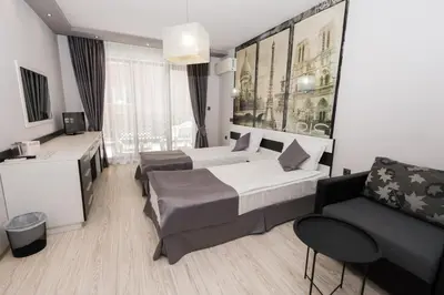 a hotel room with two beds and a couch at Polina Beach in Sozopol