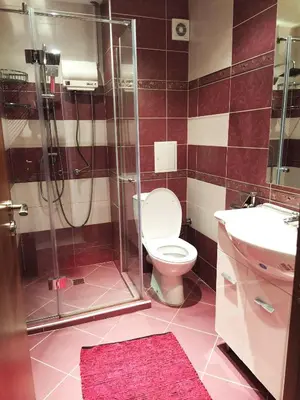 a bathroom with a toilet and a shower and a sink at Modern apartment in Burgas in Burgas City