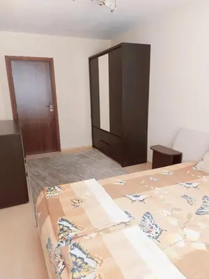 a bedroom with a bed and a cabinet in it at Modern apartment in Burgas in Burgas City