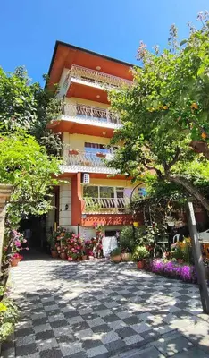 a building with a lot of flowers in front of it at Violeta 7 Guest House in Nesebar