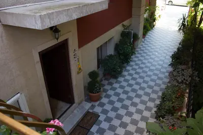a building with a courtyard with potted plants and a door at Violeta 7 Guest House in Nesebar