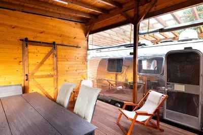 a table and chairs in a room with an rv at Luxury Vintage Airstream RV/Caravan Retro Charm Meets Comfort in Kiten